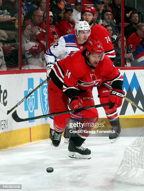 Justin Williams of the Carolina Hurricanes skates away with the puck ahead of Filip Chytil of the New York Rangers during an NHL game on March 31,...