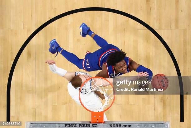 Devonte' Graham of the Kansas Jayhawks drives to the basket against Donte DiVincenzo of the Villanova Wildcats in the first half during the 2018 NCAA...