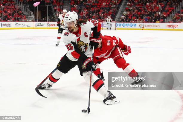 Erik Karlsson of the Ottawa Senators tries to control the puck in front of Dylan Larkin of the Detroit Red Wings during the third period at Little...