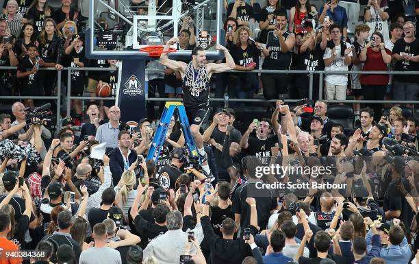 Melbourne United captain Chris Goulding celebrates with fans as he cuts down the net after winning game five of the NBL Grand Final series between...