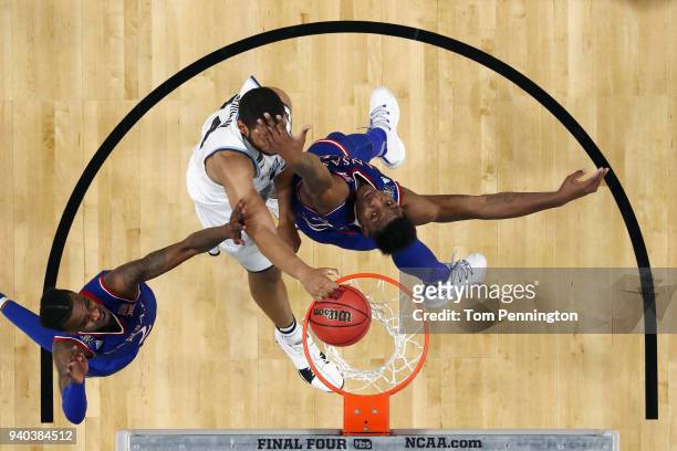 Omari Spellman of the Villanova Wildcats goes up for a dunk against Silvio De Sousa and Lagerald Vick of the Kansas Jayhawks in the first half during...