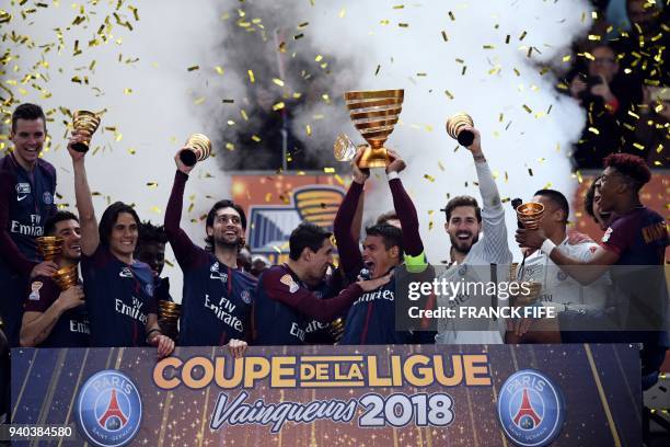Paris Saint-Germain's Brazilian defender Thiago Silva holds the trophy as he celebrates with teammates after victory in the French League Cup final...