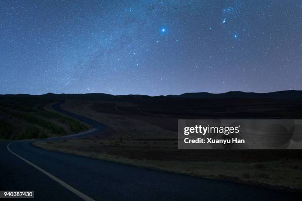 road trip under the milky way - landstraße stock-fotos und bilder