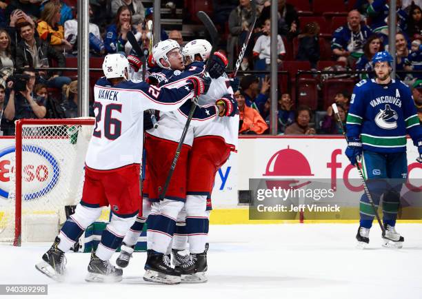 Alexander Edler of the Vancouver Canucks looks on as Thomas Vanek, Seth Jones and Pierre-Luc Dubois of the Columbus Blue Jackets celebrate a goal...