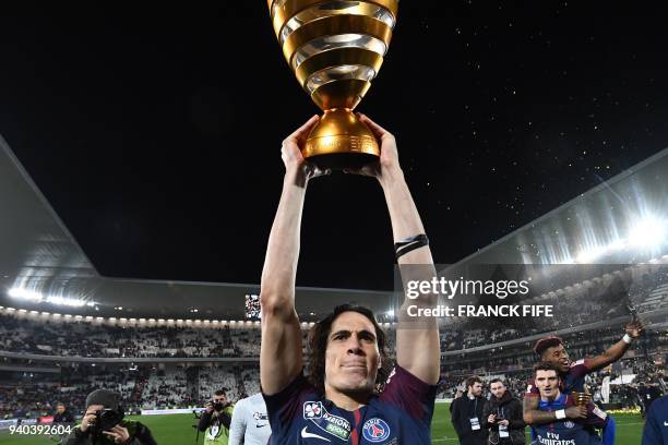 Paris Saint-Germain's Uruguayan forward Edinson Cavani celebrates with the trophy after victory in the French League Cup final football match between...