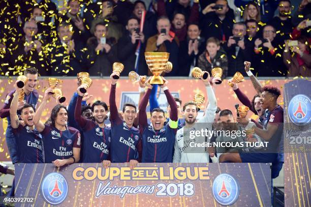 Paris Saint-Germain's Brazilian defender Thiago Silva holds the trophy as he celebrates with teammates German goalkeeper Kevin Trapp , French...