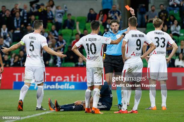 Referee Shaun Evans issues a red card to Michael Thwaite of the Wanderers during the round 25 A-League match between the Melbourne Victory and the...