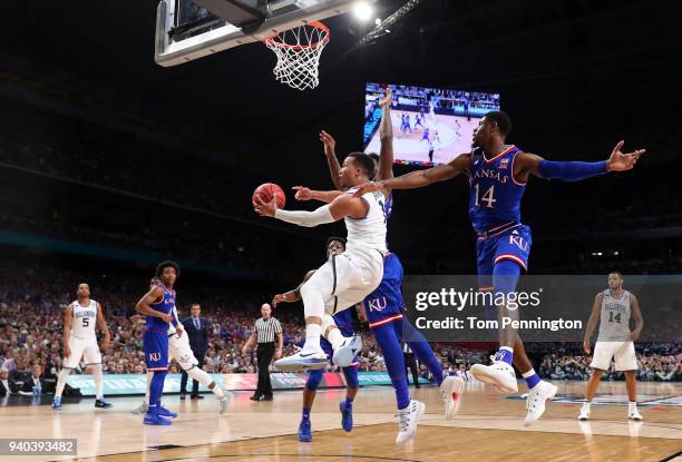 Jalen Brunson of the Villanova Wildcats drives to the basket against Silvio De Sousa and Malik Newman of the Kansas Jayhawks in the secoond half...