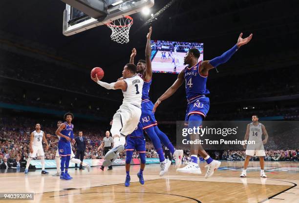 Jalen Brunson of the Villanova Wildcats drives to the basket against Silvio De Sousa and Malik Newman of the Kansas Jayhawks in the secoond half...