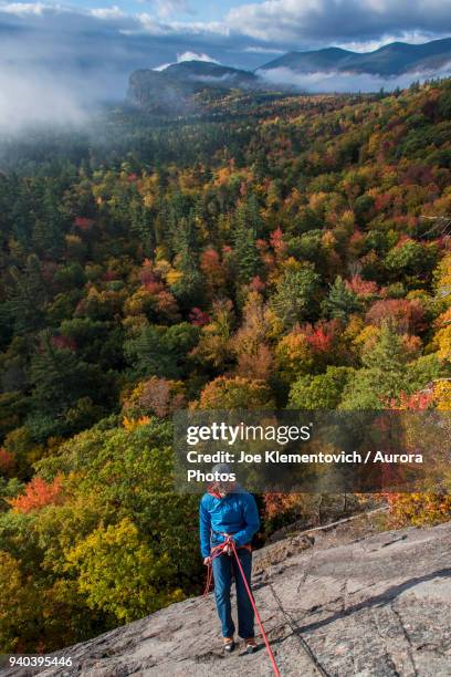 front view of climber standing on front of colorful forest, north conway, new hampshire, usa - new hampshire stock-fotos und bilder