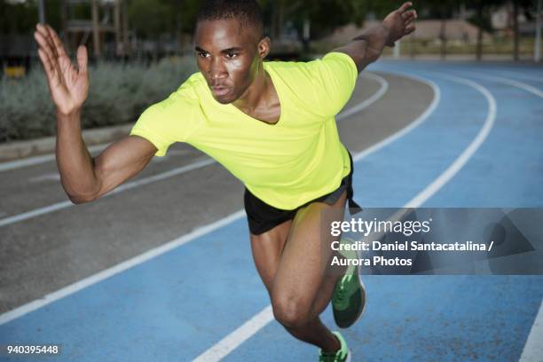 male athlete sprinting on all-weather running track, barcelona, spain - all weather running track stock pictures, royalty-free photos & images