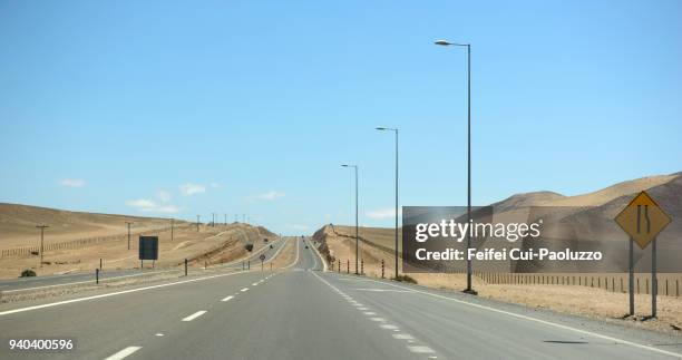 road and road narrowing on right side sign near caldera, chile - copiapo stock pictures, royalty-free photos & images