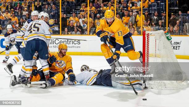 Nick Bonino of the Nashville Predators leaps goalie Chad Johnson of the Buffalo Sabres to collect a loose puck during an NHL game at Bridgestone...