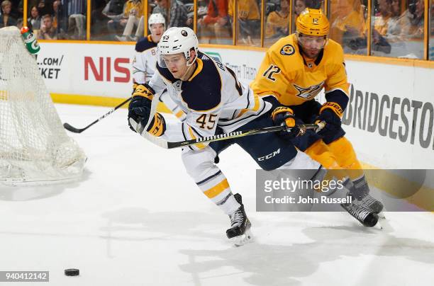 Mike Fisher of the Nashville Predators lifts the stick of Brendan Guhle of the Buffalo Sabres during an NHL game at Bridgestone Arena on March 31,...