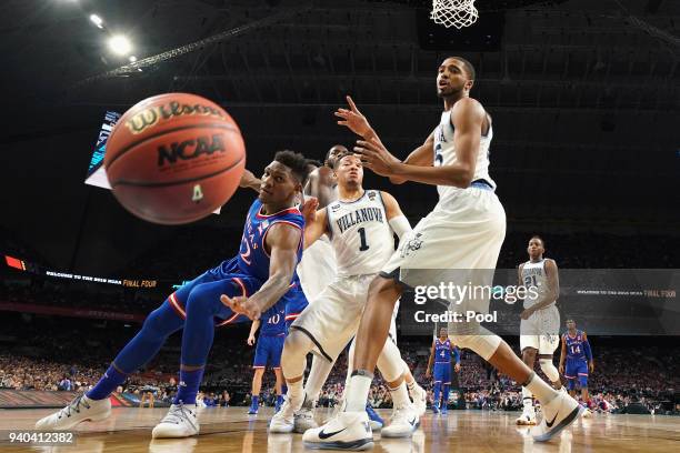 Silvio De Sousa of the Kansas Jayhawks competes for a loose ball with Jalen Brunson and Mikal Bridges of the Villanova Wildcats in the first half in...