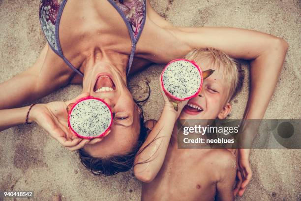 glückliche frau und junge setzt drachenfrucht als gläser. - boy thailand stock-fotos und bilder