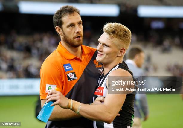Adam Treloar of the Magpies catches up with former Giants teammate and current Giants Assistant Coach Shane Mumford during the 2018 AFL round 02...