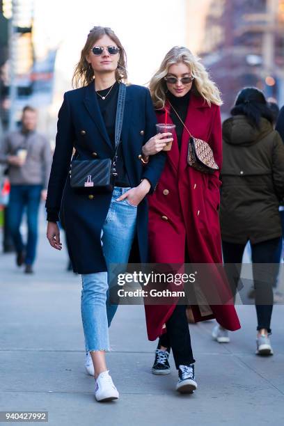 Constance Jablonski wearing an Yves Saint Laurent coat with Celine shoes and Off-White handbage and Elsa Hosk wearing a Le Ru Basics coat are seen in...