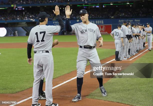 Aaron Judge of the New York Yankees is welcomed by manager Aaron Boone and teammates during pre-game introductions on Opening Day before the start of...