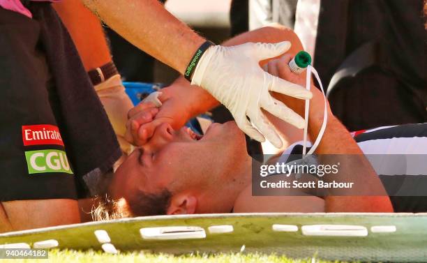 Tim Broomhead of the Magpies is given the green whistle as he lies on the field with a broken leg during the round two AFL match between the...