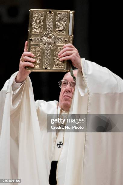 Pope Francis holds Holy Bible during he has presides over a solemn Easter vigil ceremony in St. Peter's Basilica at the Vatican, Saturday, March 31,...