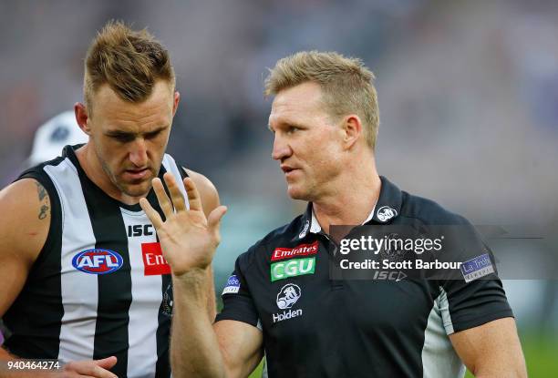 Nathan Buckley, coach of the Magpies speaks to Lynden Dunn of the Magpies during a quarter time break during the round two AFL match between the...