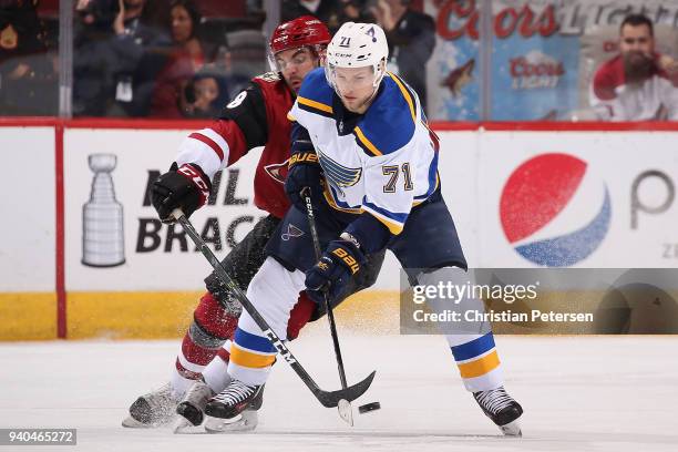 Vladimir Sobotka of the St. Louis Blues skates with the puck under pressure from Jordan Martinook of the Arizona Coyotes during the third period of...