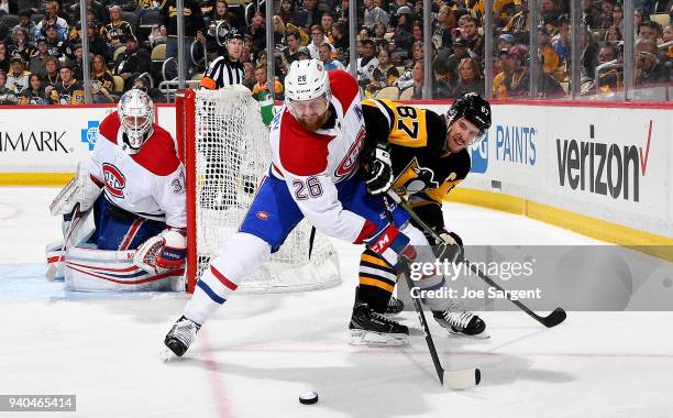 Sidney Crosby of the Pittsburgh Penguins and Jeff Petry of the Montreal Canadiens battle at PPG Paints Arena on March 31, 2018 in Pittsburgh,...