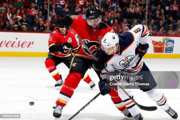 Mark Giordano of the Calgary Flames skates against Ty Rattie of the Edmonton Oilers during an NHL game on March 31, 2018 at the Scotiabank Saddledome...