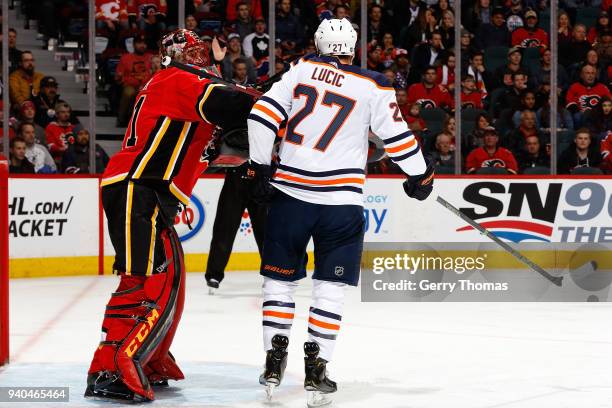 Mike Smith of the Calgary Flames pushes Milan Lucic of the Edmonton Oilers during an NHL game on March 31, 2018 at the Scotiabank Saddledome in...