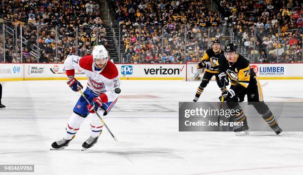 Alex Galchenyuk of the Montreal Canadiens handles the puck against Evgeni Malkin of the Pittsburgh Penguins at PPG Paints Arena on March 31, 2018 in...