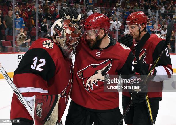 Goalie Antti Raanta of the Arizona Coyotes is congratulated by teammate Derek Stepan after a 6-0 shutout victory against the St Louis Blues at Gila...