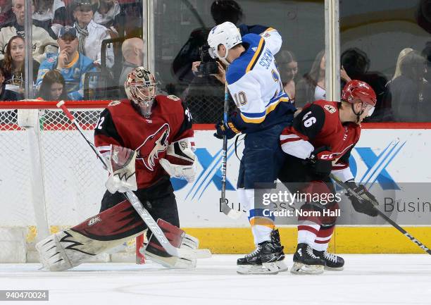 Goalie Antti Raanta of the Arizona Coyotes stops the puck as Brayden Schenn of the St Louis Blues and Trevor Murphy of the Coyotes battle in front of...