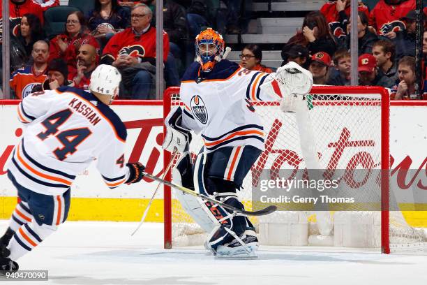 Cam Talbot of the Edmonton Oilers points to the puck during an NHL game against the Calgary Flames on March 31, 2018 at the Scotiabank Saddledome in...