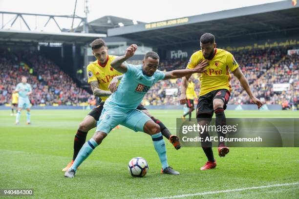 Callum Wilson of Bournemouth holds off Jose Holebas of Watford and Adrian Mariappa of Watford during the Premier League match between Watford and AFC...