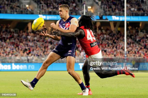 Stephen Hill of the Dockers handpasses the ball under pressure from Anthony McDonald-Tipungwuti of the Bombers during the round two AFL match between...