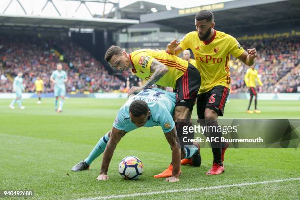 Callum Wilson of Bournemouth holds off Jose Holebas of Watford and Adrian Mariappa of Watford during the Premier League match between Watford and AFC...