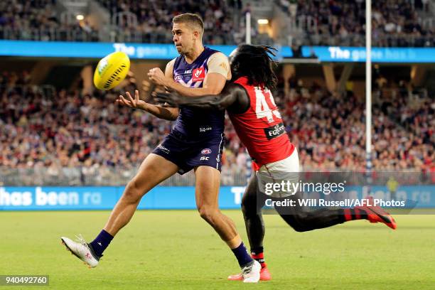 Stephen Hill of the Dockers handpasses the ball under pressure from Anthony McDonald-Tipungwuti of the Bombers during the round two AFL match between...