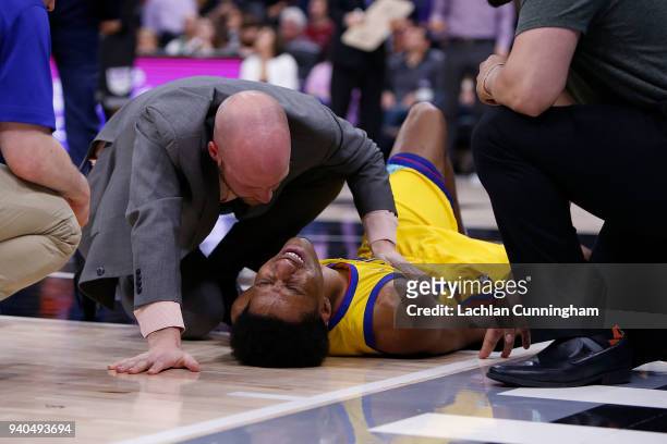 Patrick McCaw of the Golden State Warriors is attended to by team medical staff after being fouled by Vince Carter of the Sacramento Kings at Golden...