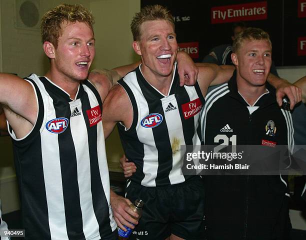 Ben Johnson, Nathan Buckley and Tarkyn Lockyer for Collingwood sing the team song in the rooms, after the Round 2 AFL Match between the Collingwood...