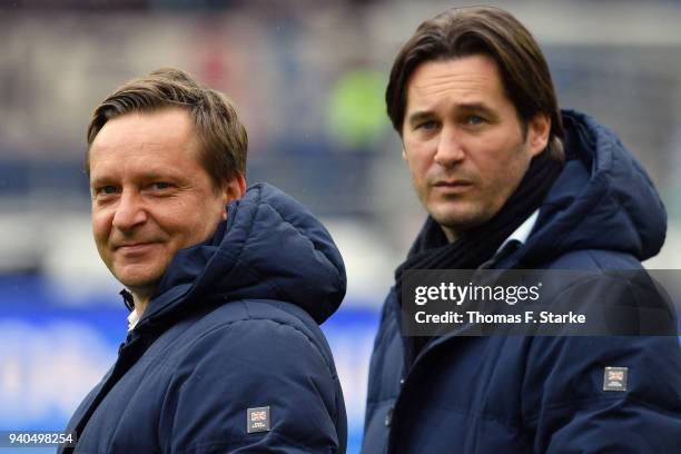 Manager Horst Heldt and sports director Gerhard Zuber of Hannover look on prior to the Bundesliga match between Hannover 96 and RB Leipzig at...