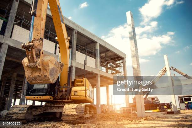 construction equipment in construction new warehouse background - bulldozer house stock pictures, royalty-free photos & images
