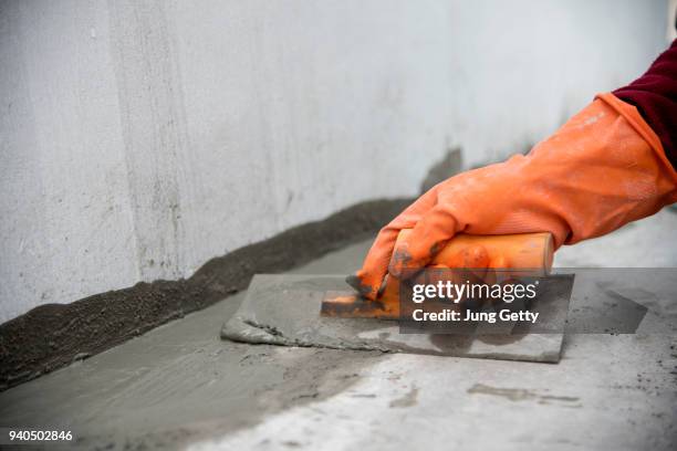 close up hand labor hold trowel masonry work in construction site - baustelle beton stock-fotos und bilder