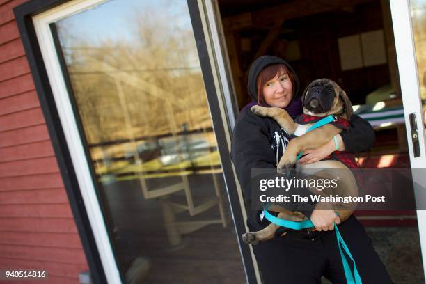 Jenny Pacanowski carries her Bullmastiff puppy out after leads a writing workshop for combat women with her organization FVET in Bethlehem, PA March...
