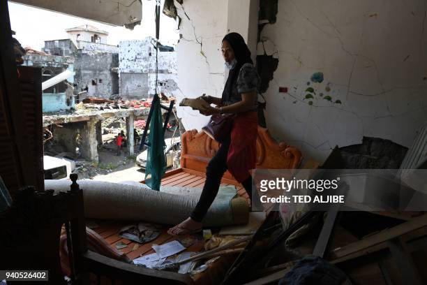 Residents collects documents and belongings from her destroyed house during a visit to the main battle area in Marawi City, in southern island of...