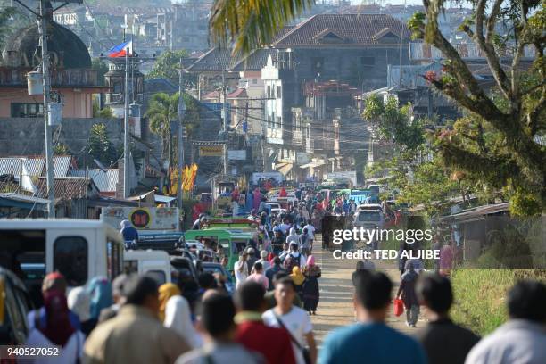 Thousands of residents wait to pass through a military check point after authorities allowed them to visit their destroyed houses at the main battle...