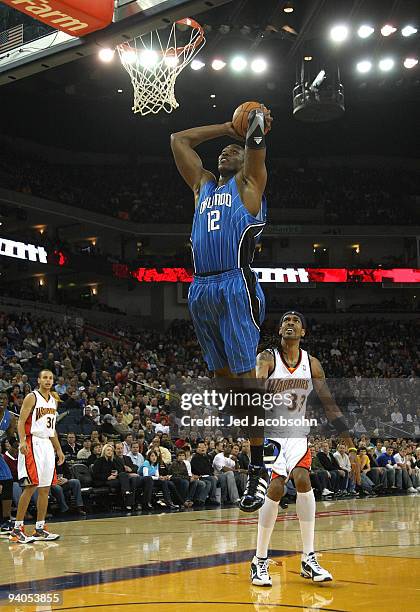 Dwight Howard of the Orlando Magic scores against Mikki Moore of the Golden State Warriors during an NBA game at Oracle Arena on December 5, 2009 in...