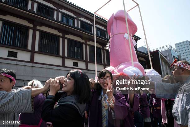 People carry a large pink phallus shaped portable shrine during the annual Kanamara Festival at Kanayama Shrine in Kawasaki on April 1 Kawasaki,...