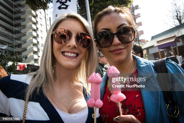 Festival goers pose for photos with their phalluses shapes lollipops during the annual Kanamara Festival at Kanayama Shrine in Kawasaki on April 1...
