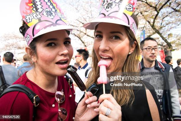 Festival goers pose for photos with their phalluses shapes lollipops during the annual Kanamara Festival at Kanayama Shrine in Kawasaki on April 1...